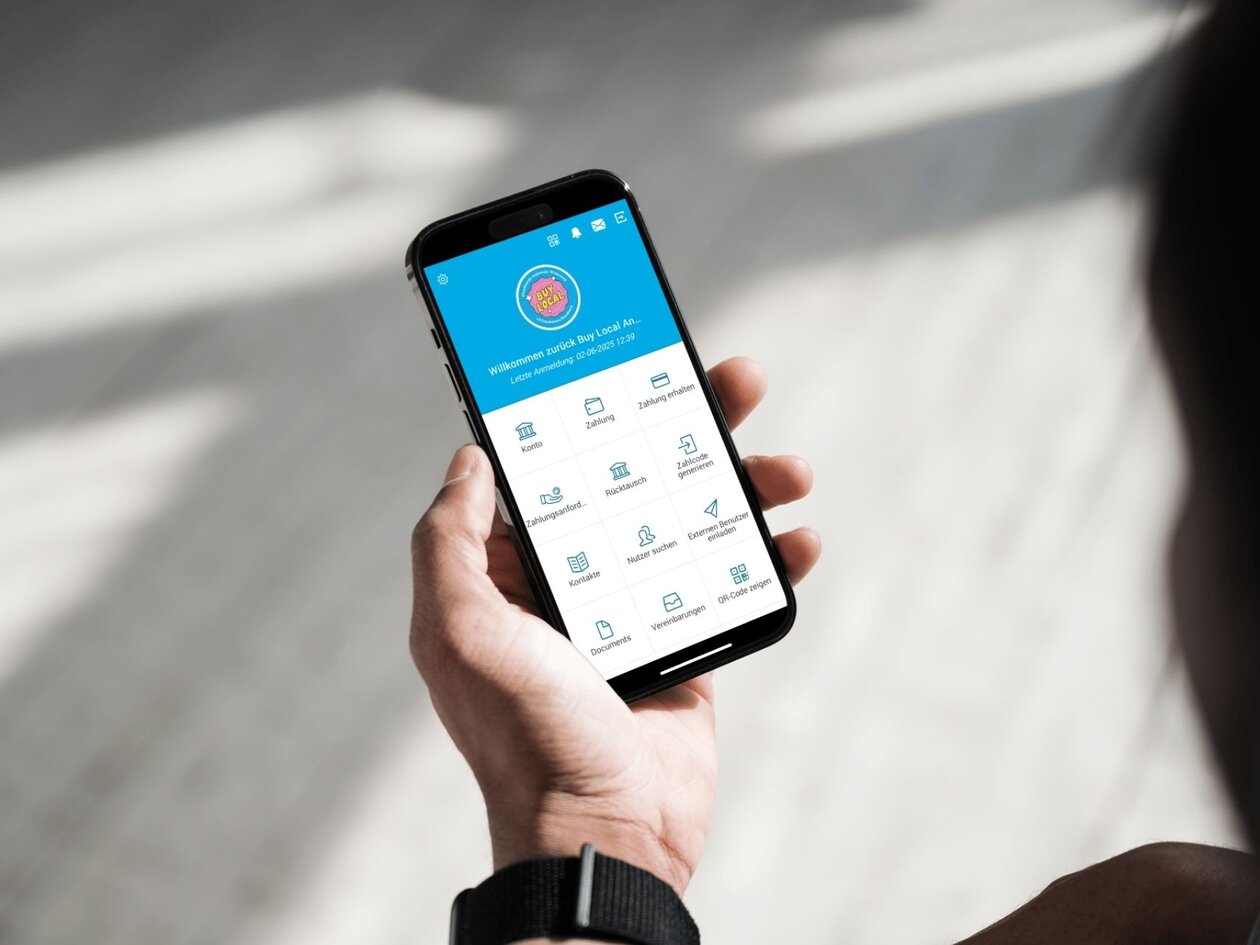 Eine Hand hält ein Smartphone, auf dem die Klimabonus App geöffnet ist. 