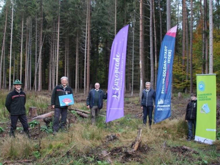 Zeigen Flagge für den Klimaschutz: Frankenbergs Bürgermeister Heß (2. v. r.) gemeinsam mit (v. l.) Revierförster Armin Wack, Forstamtsleiter Eberhard Leicht, Frank Jansky (Verein Klimabonus) und dessen Sohn.